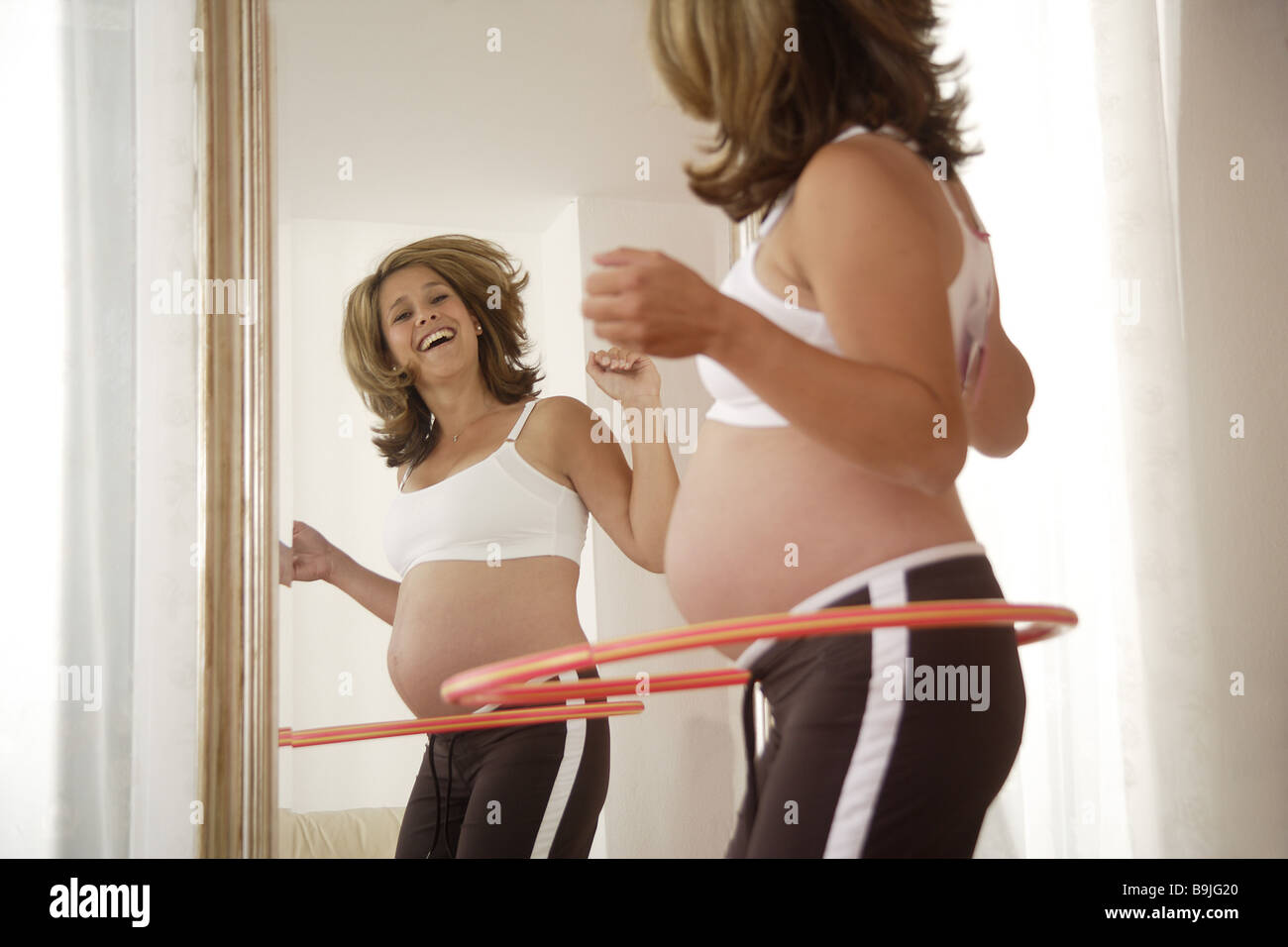 Woman pregnant mirrors hula hoop 20-30 years 25-30 years mobility movement  one person adults family-lives woman leisurewear Stock Photo - Alamy