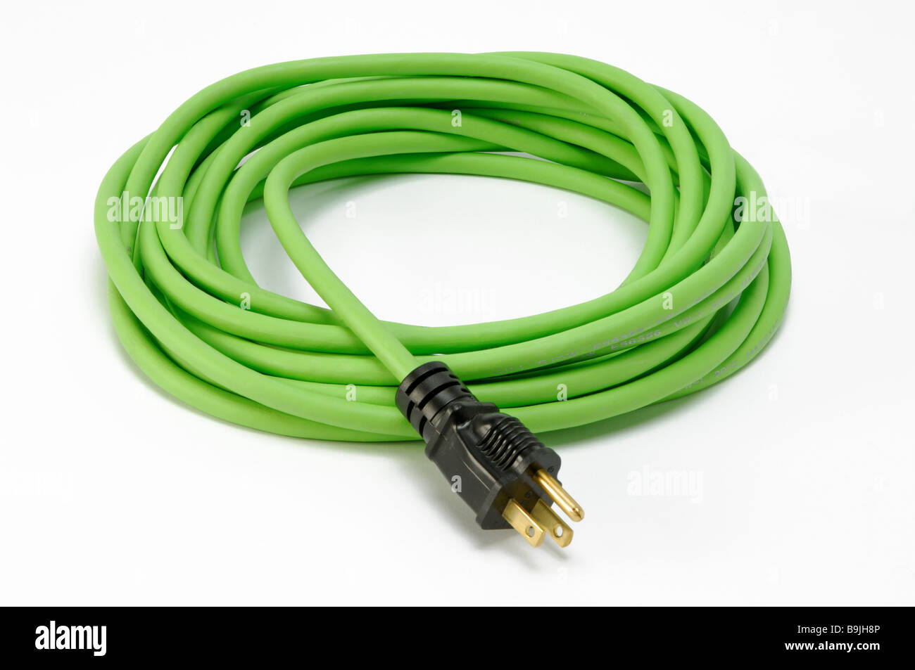 A coiled green electrical extension power cord with one plug Stock Photo