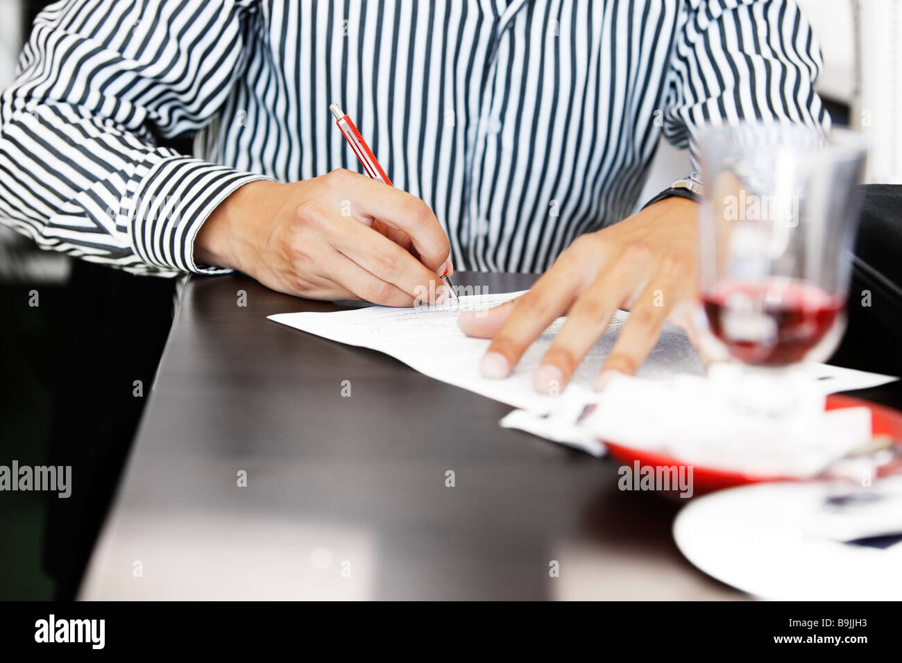 close up of man signing contract or making to do list Stock Photo