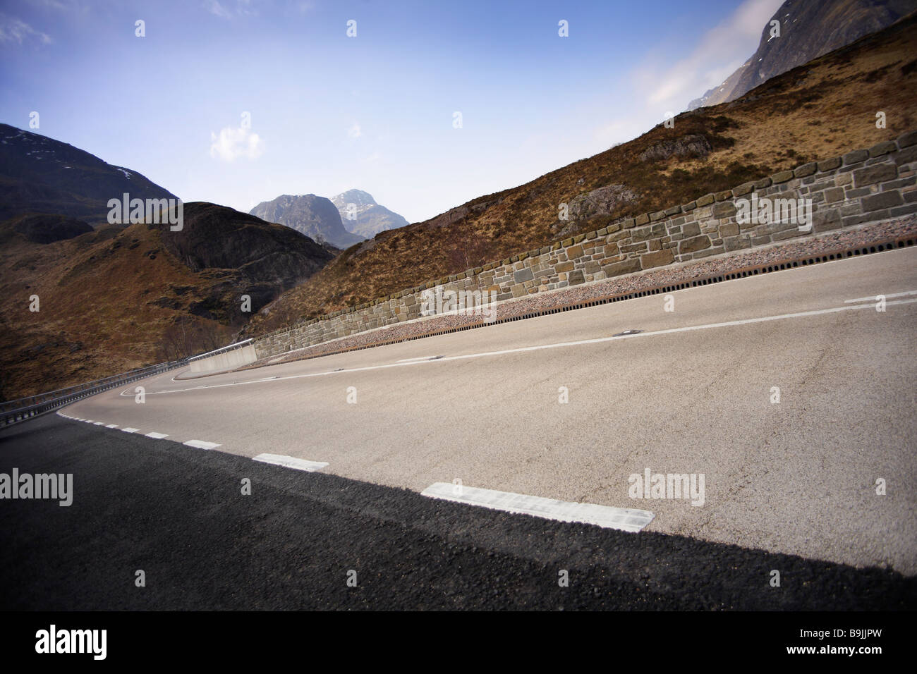 new road,sweeping curve,blue sky,no traffic. Stock Photo