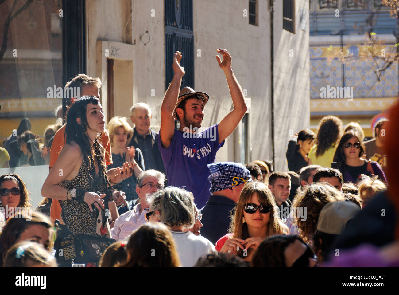 Young people listening to a band busking during Las Fallas festival in the historical city centre of Valencia Spain Stock Photo