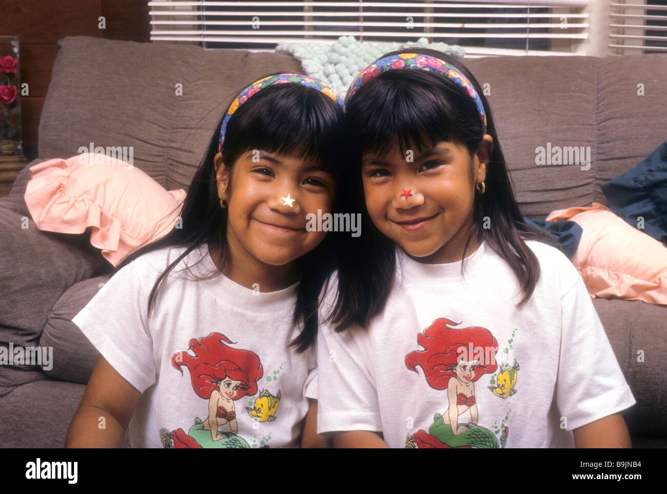 Twin latina girls hug touch smile love sister Hispanic portrait happy enjoy share together sibling face Stock Photo