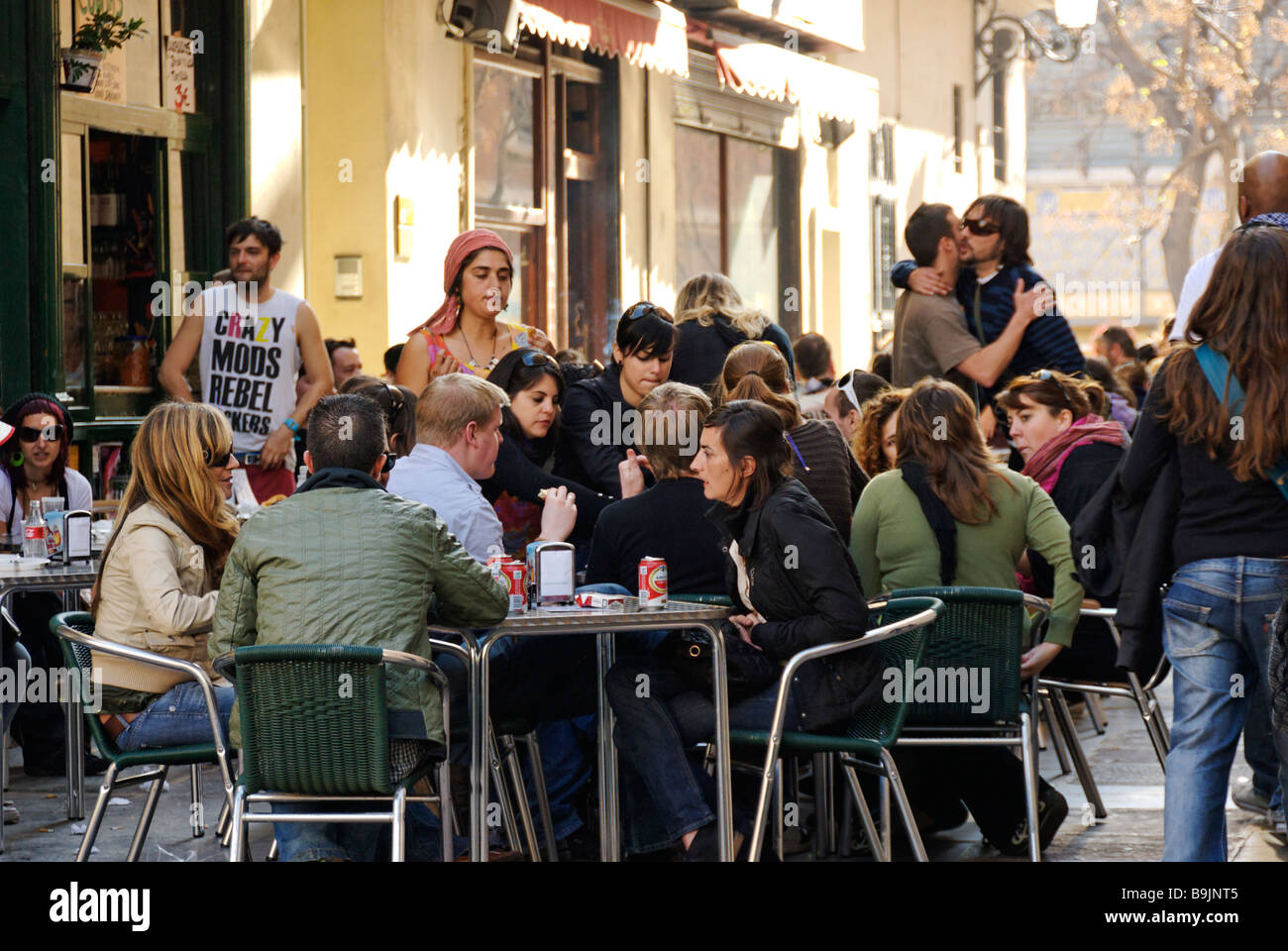 People sitting outside a busy cafe in El Carmen during las Fallas festival historic city centre of Valencia Spain Stock Photo