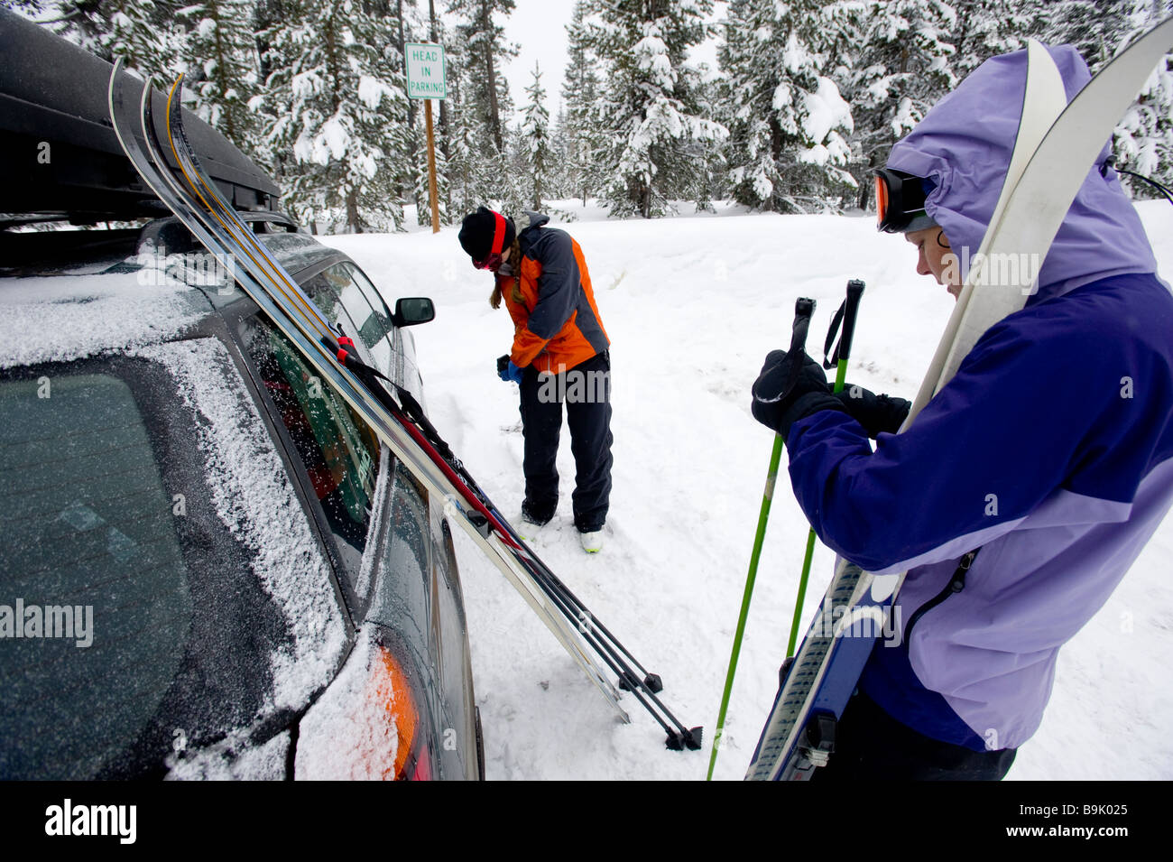 Two young women next to a car with cross country ski's preparing to go nordic skiing in Bend, Oregon. Stock Photo