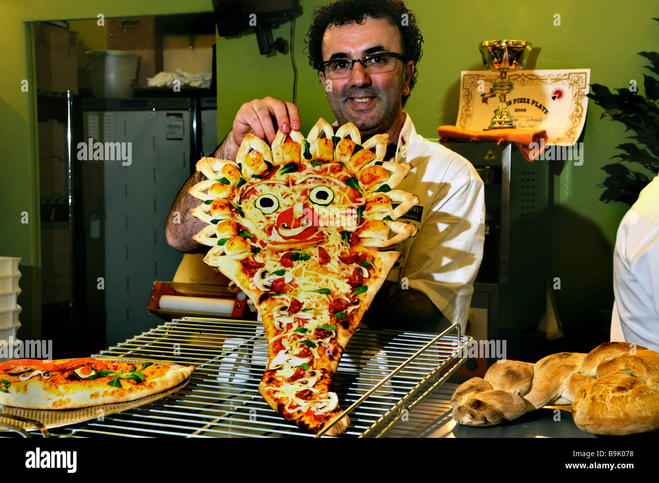 PARIS, FRANCE,  Portrait, Small Business, Food Trade Show Italian Pizza Chef, Holding Pizza Shape of Face at 'Moretti Forni' Company, Pizzeria France Stock Photo