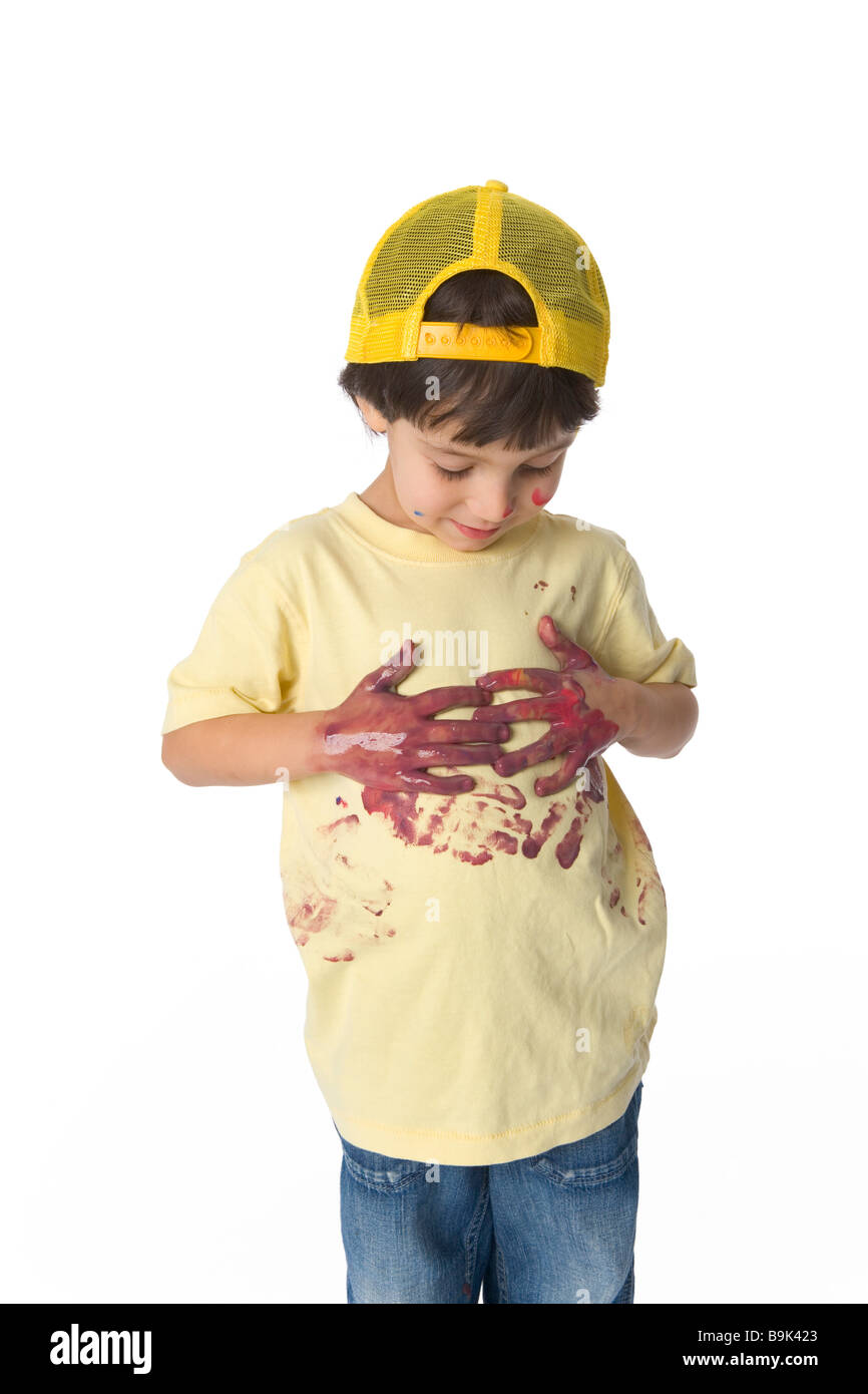 Little boy wiping hands full of paint on his t shirt Stock Photo Alamy