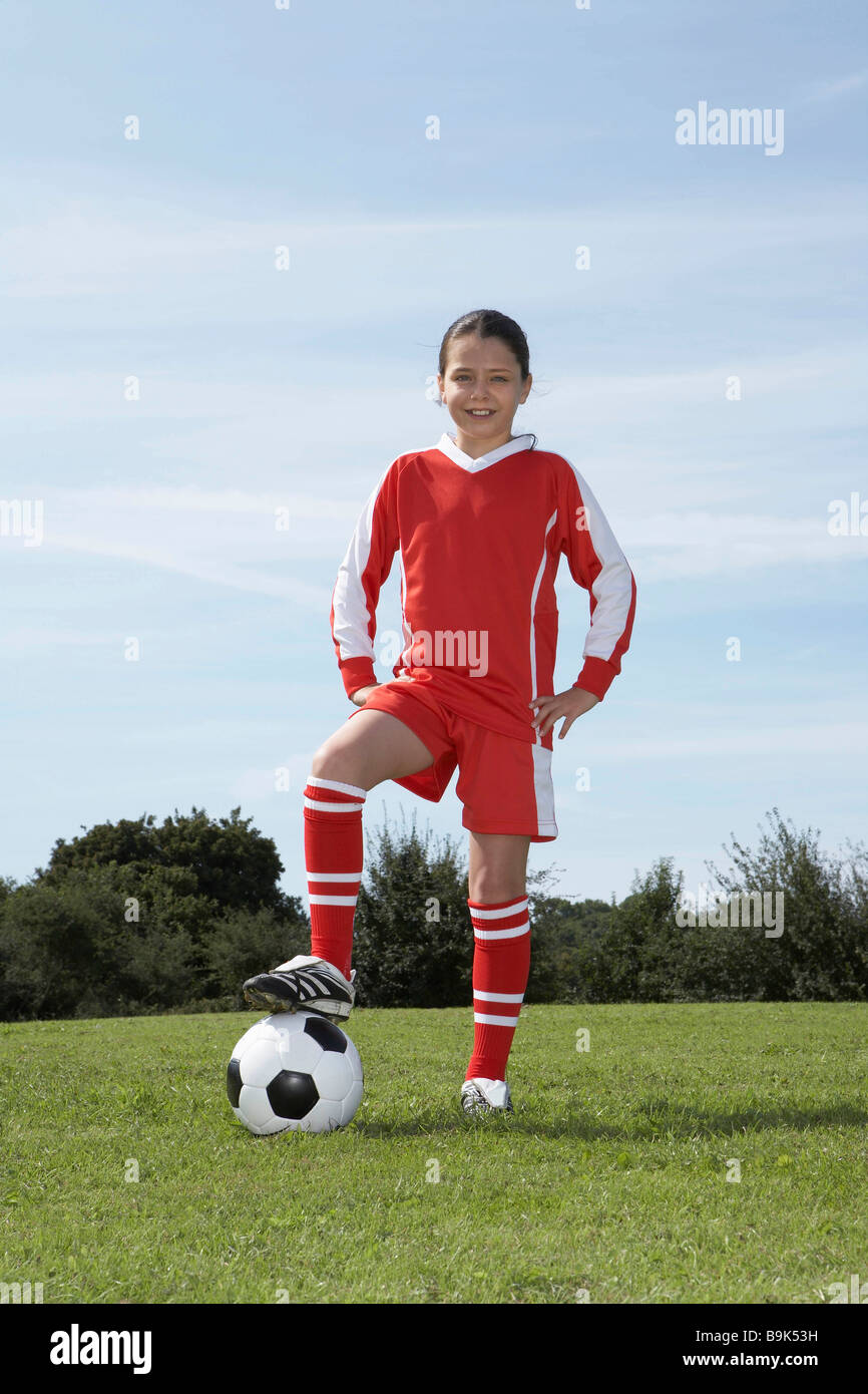 Female footballer standing with ball Stock Photo