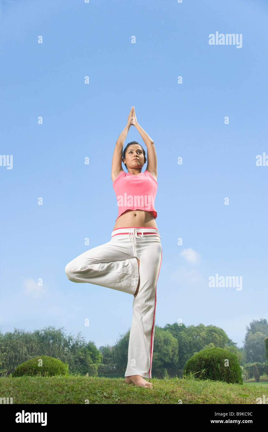 Woman practicing tree pose of yoga Stock Photo - Alamy