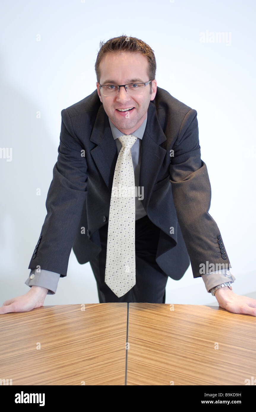 portrait of optimistic looking businessman leaning on table Stock Photo