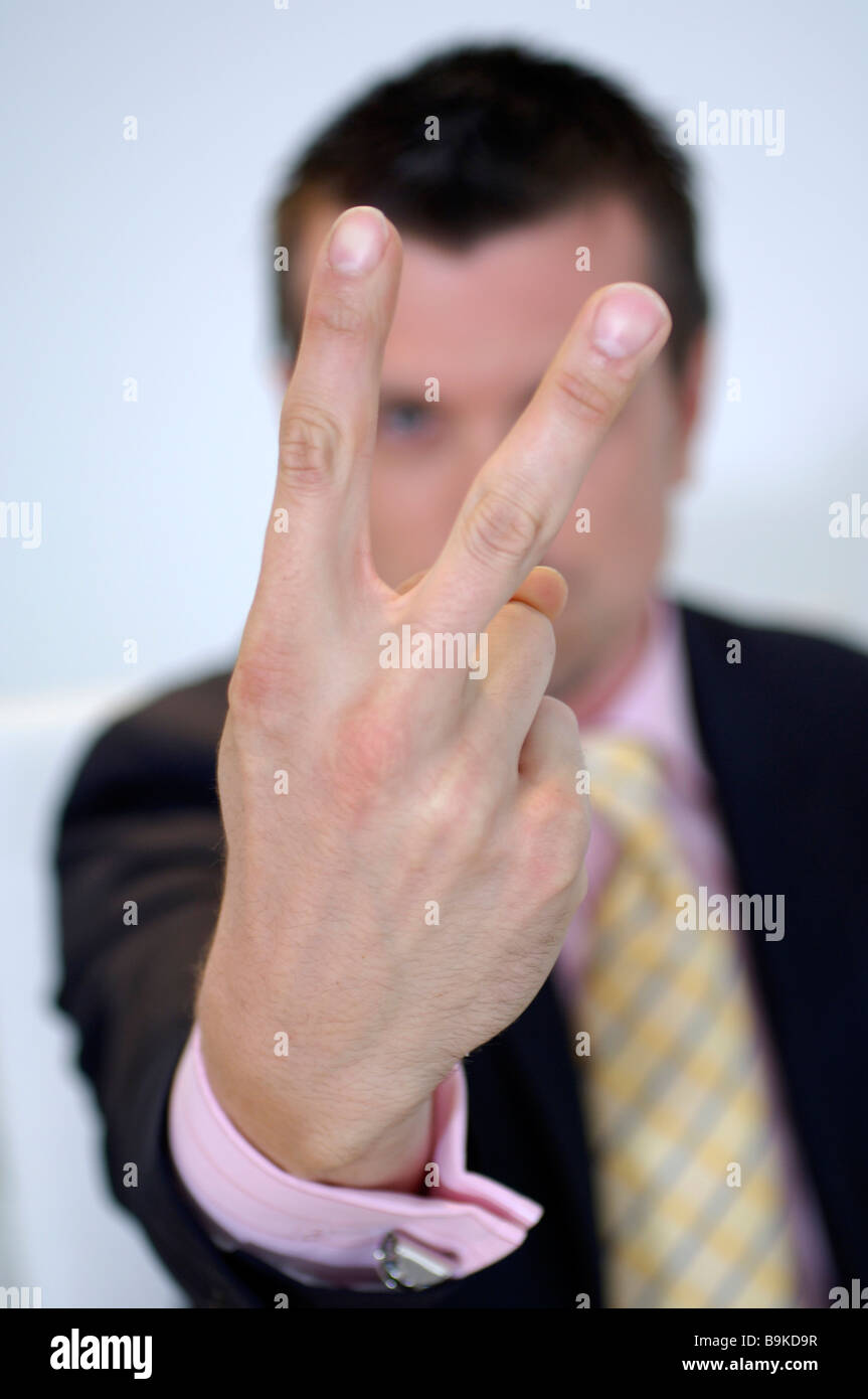 executive giving the v-sign Stock Photo