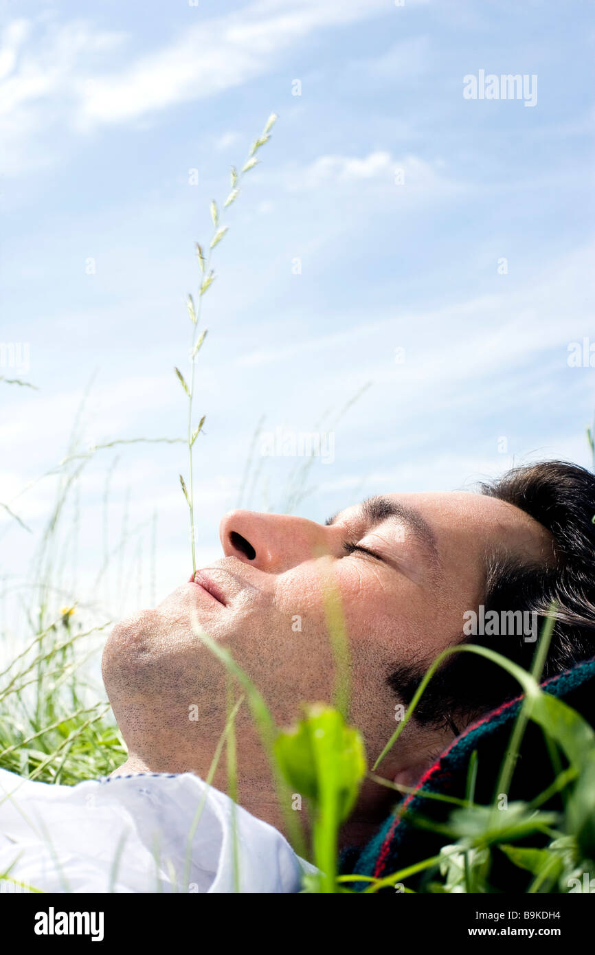 Dozing Activity portrait of young man dozing in grass Stock Photo - Alamy