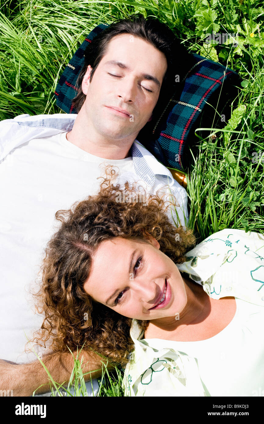 portrait of young couple relaxing in grass Stock Photo - Alamy