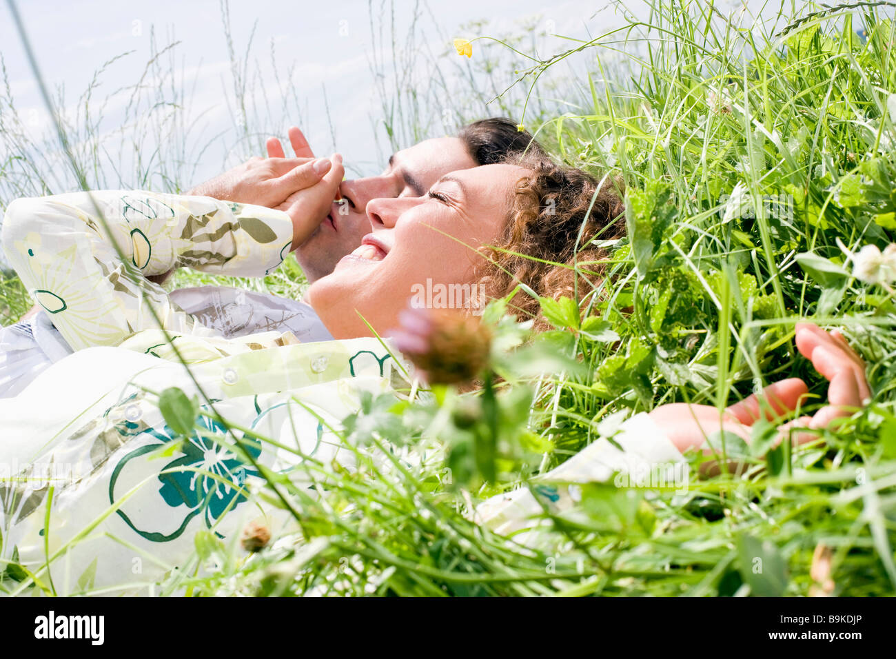 portrait of young couple relaxing in grass Stock Photo - Alamy
