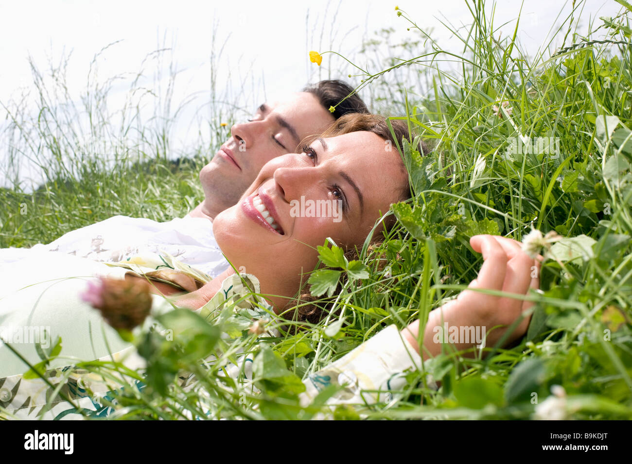 portrait of young couple relaxing in grass Stock Photo - Alamy
