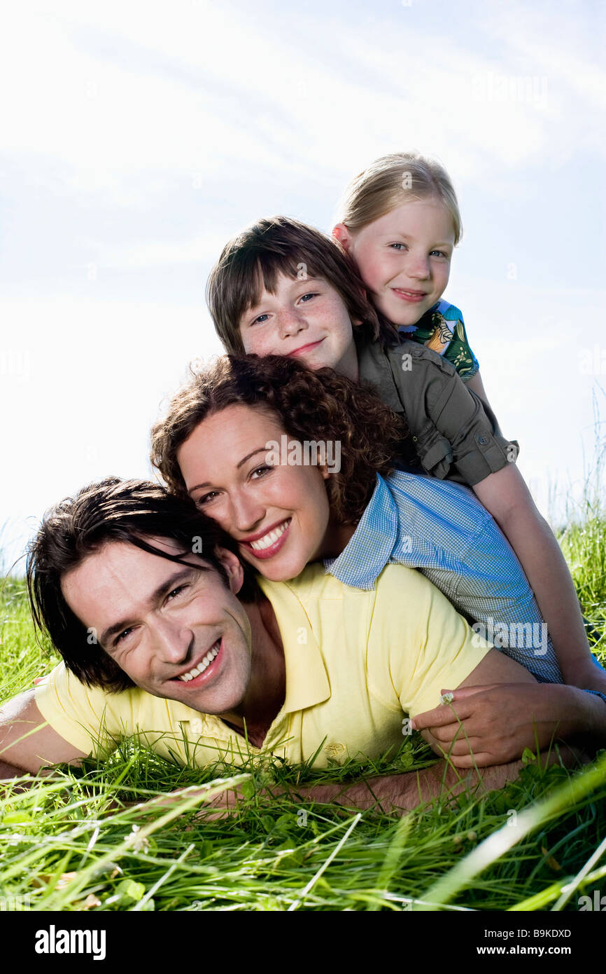 portrait of happy family lying in grass Stock Photo - Alamy