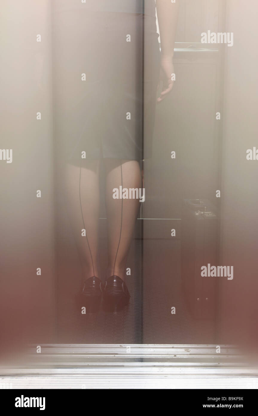 double exposure of businesswoman with seamed stockings standing in elevator Stock Photo