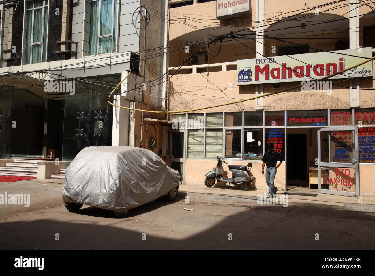 A covered car is protected from the heat in front of Maharani Hotel, Delhi India Stock Photo