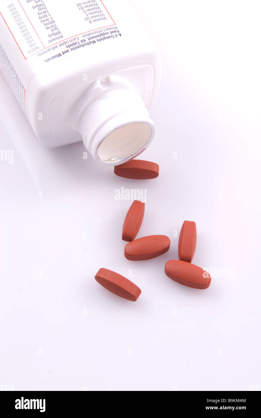 Multivitamin bottle and pills isolated against a white background Stock Photo