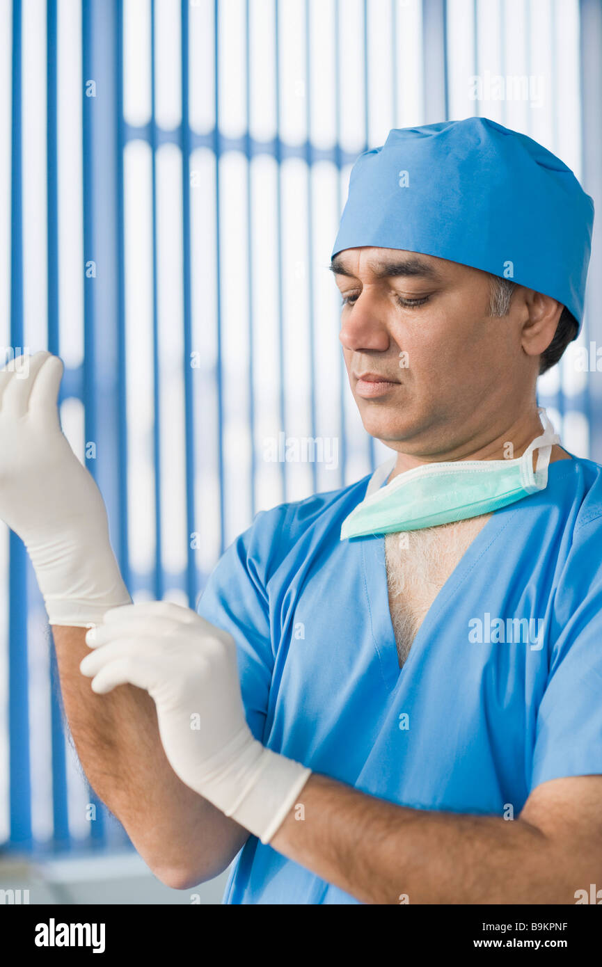 Surgeon wearing surgical gloves Stock Photo Alamy