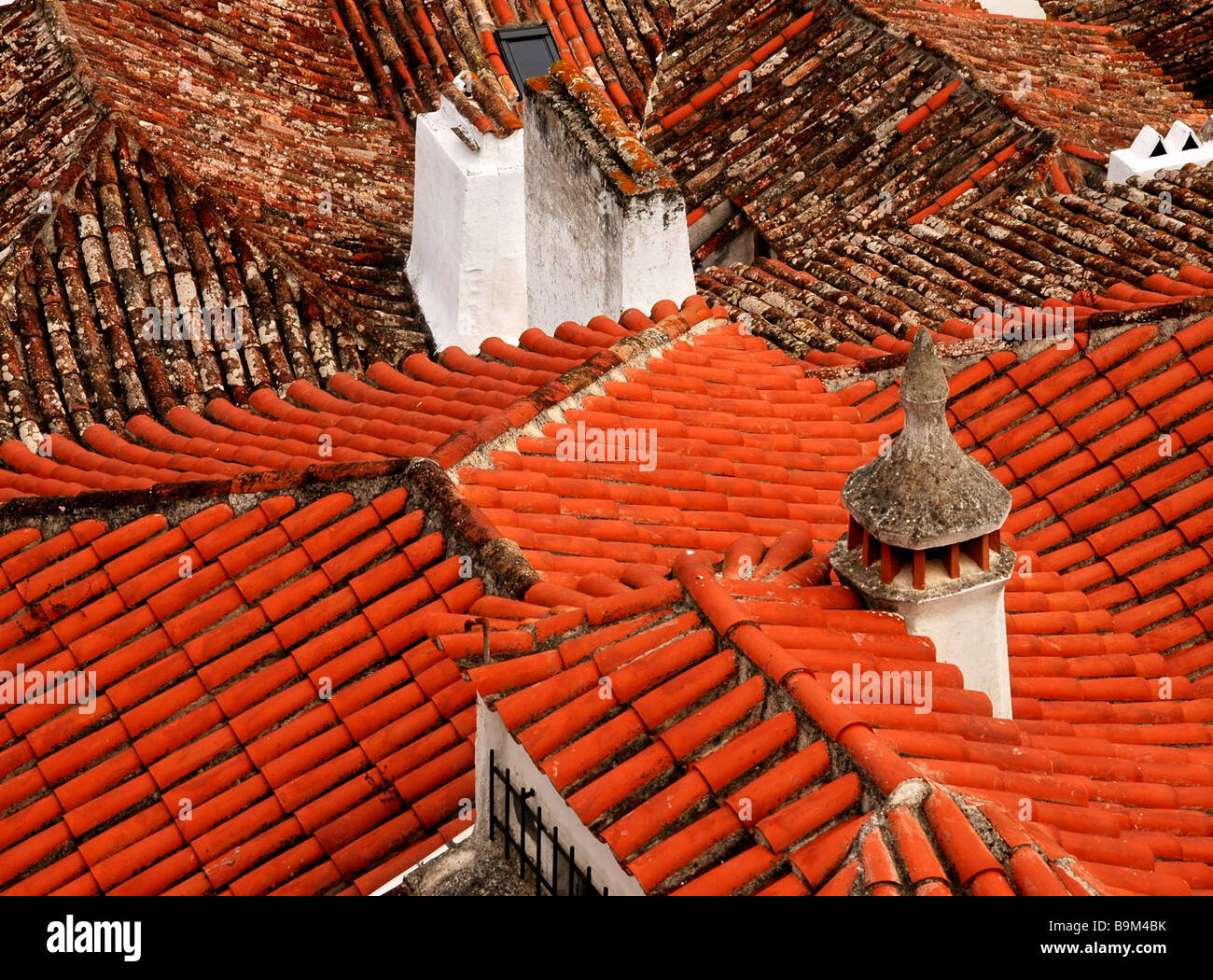 Detail of red tiled roofs and chimneys of houses in the medieval town of Obidos, Portugal. Stock Photo
