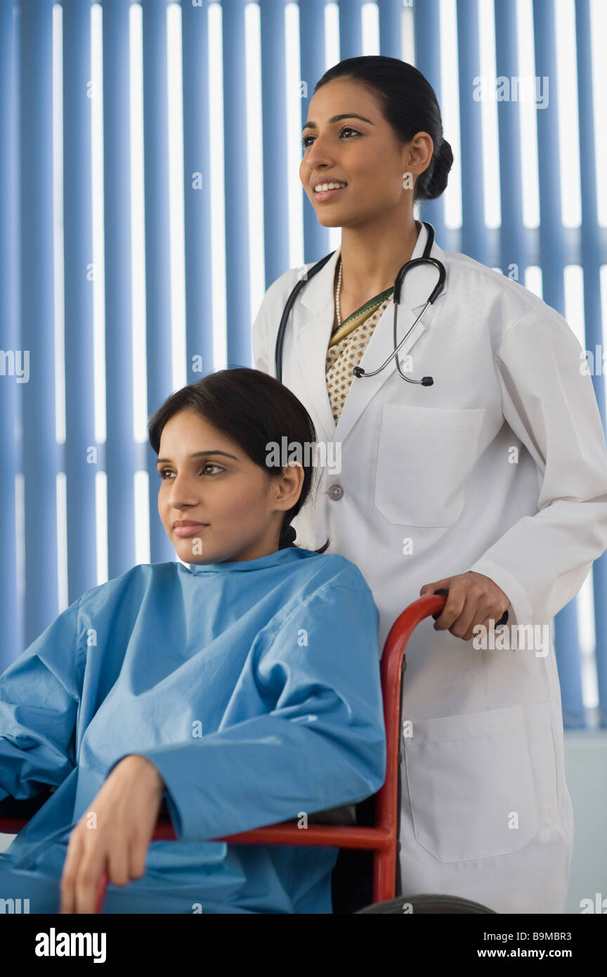 Female doctor pushing female patient on wheelchair Stock Photo - Alamy