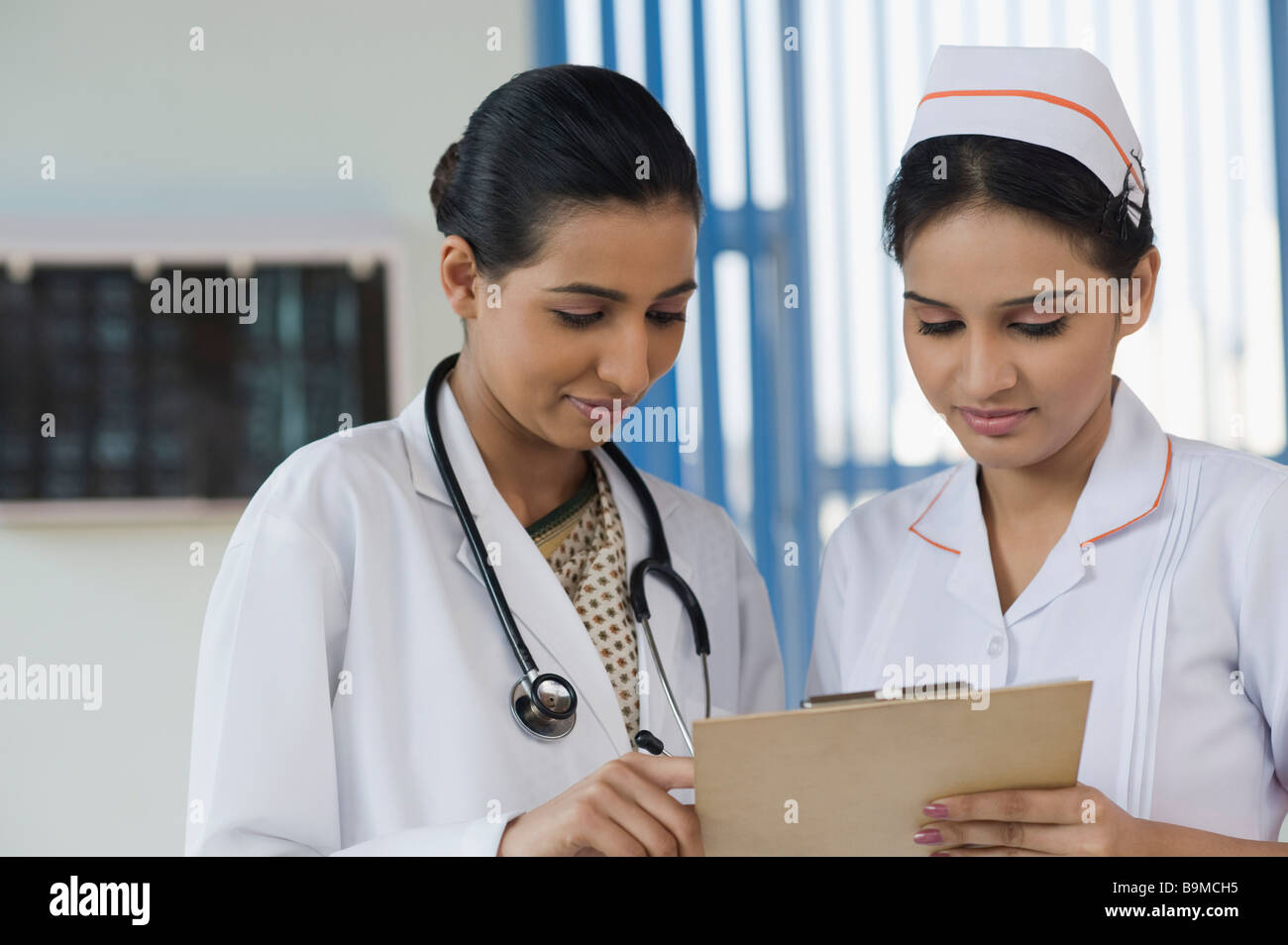 Female doctor and a nurse discussing a report Stock Photo