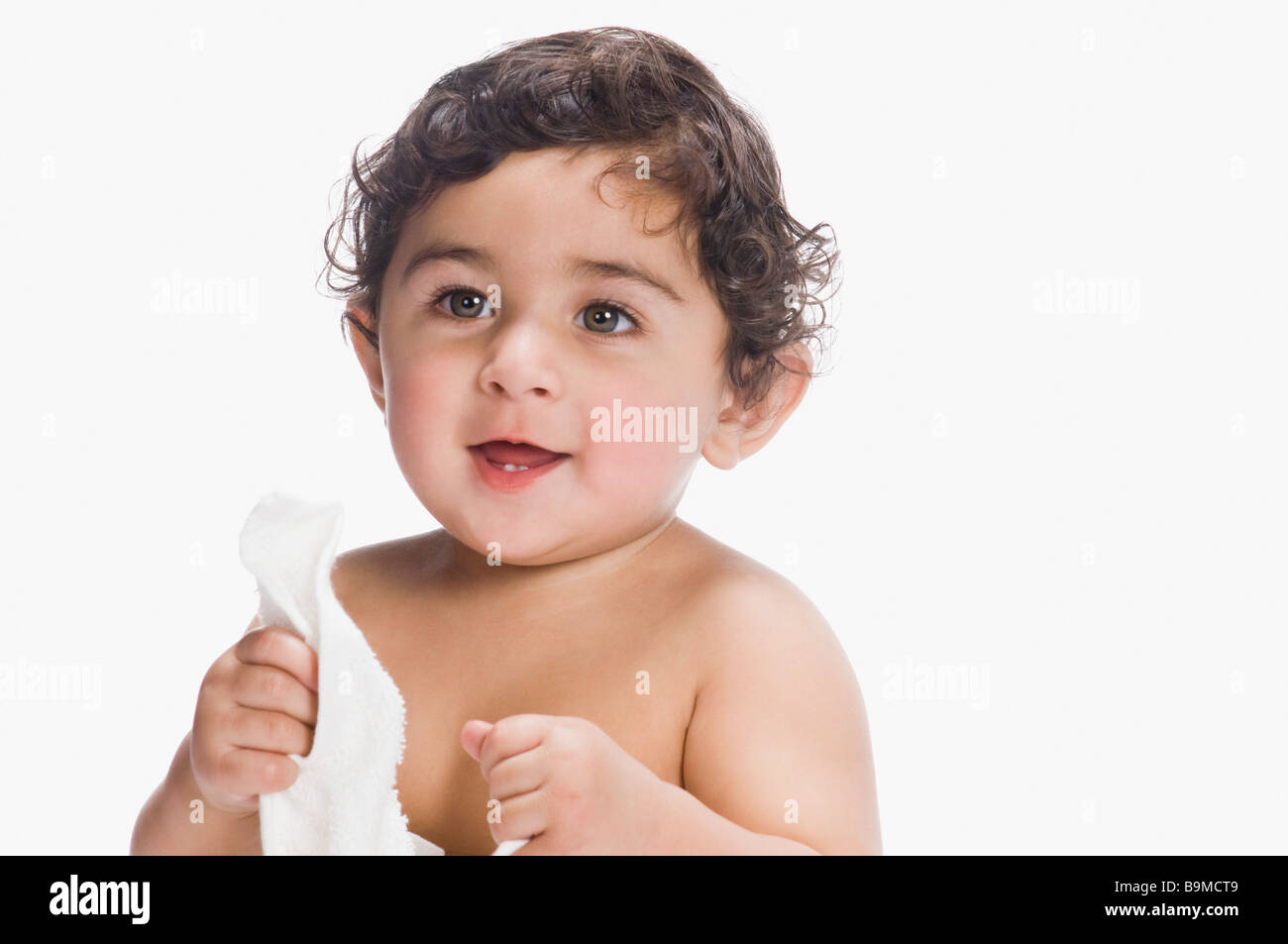 Baby boy holding a diaper and smiling Stock Photo Alamy