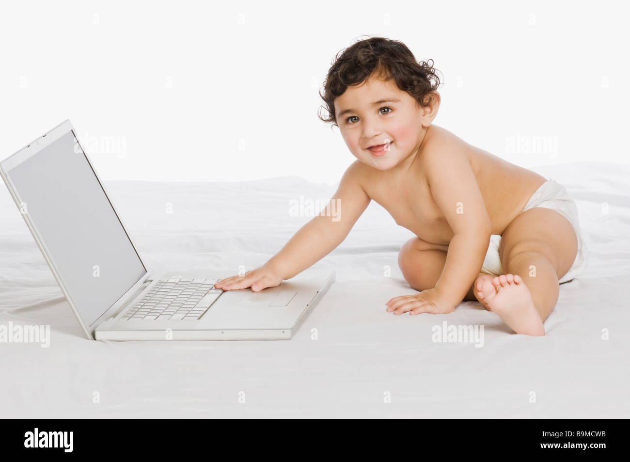 Baby boy playing with a laptop Stock Photo