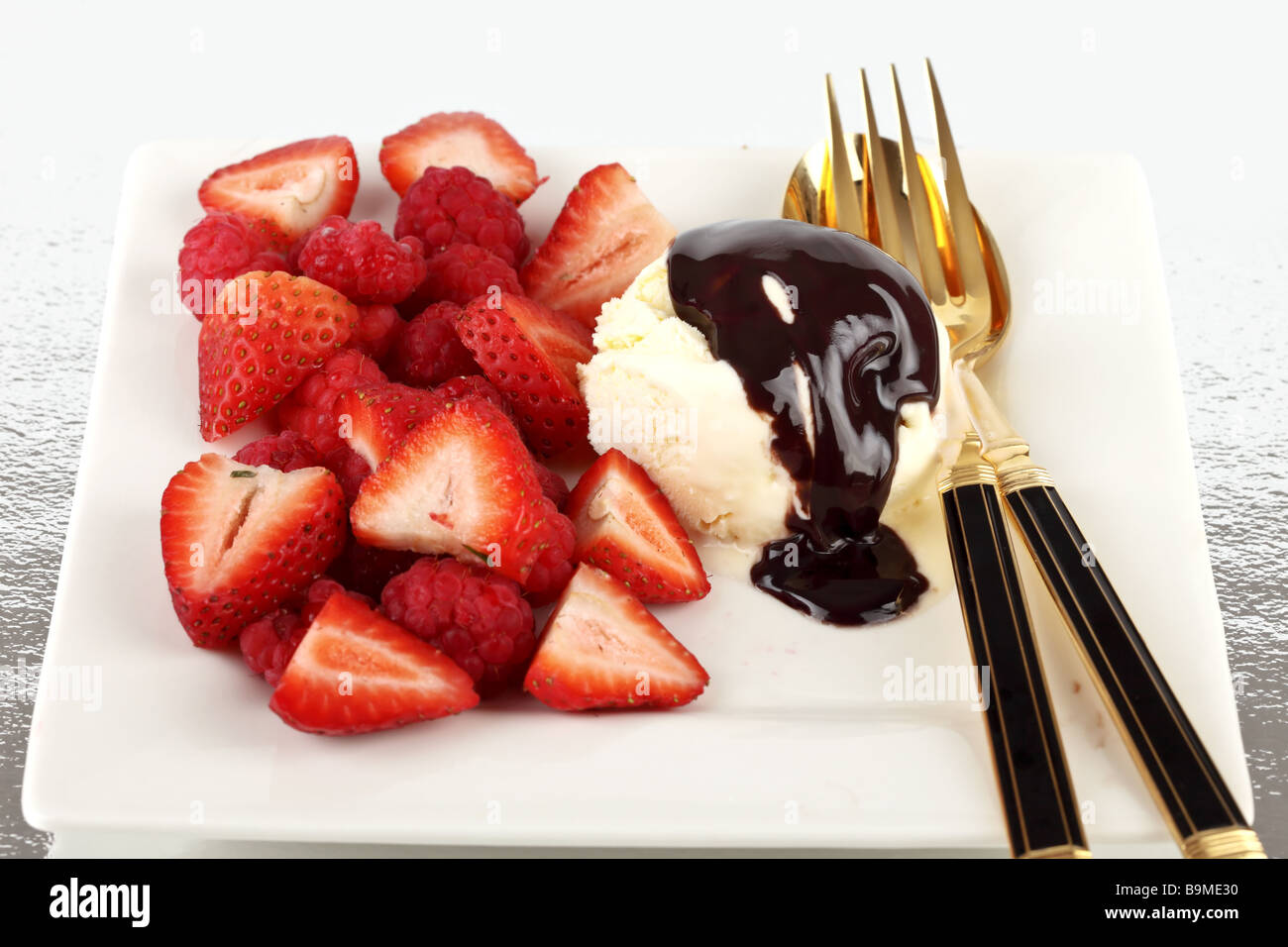 Strawberries raspberries and ice cream ready for eating on a plate Stock Photo