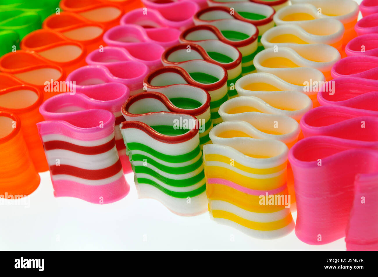 Close up of diagonal strips of colorful twisted thin ribbon candy Stock Photo