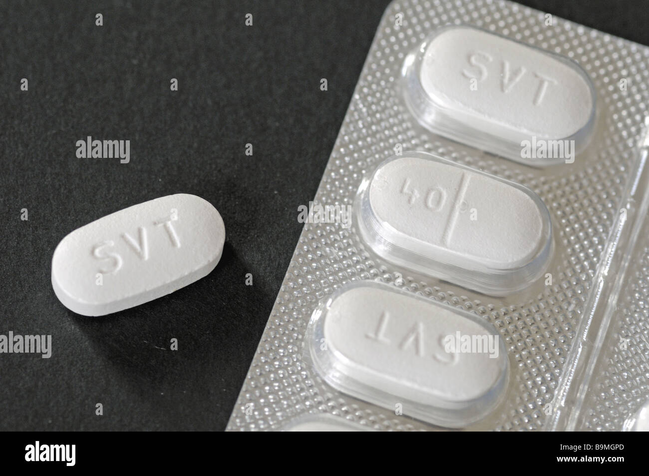 Simvastatin tablets in foil blister pack on black background Stock Photo