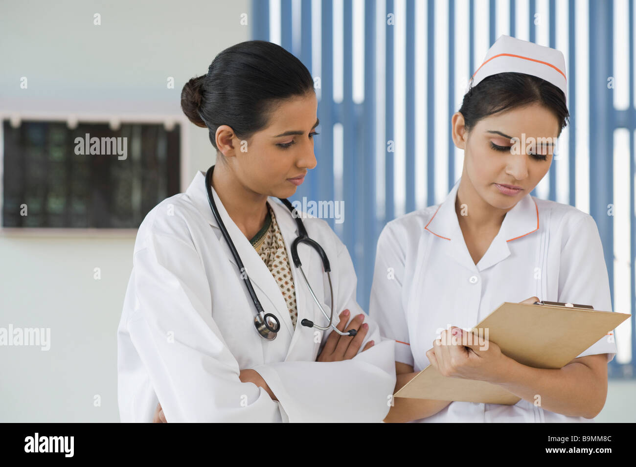 Female doctor and a nurse discussing a report Stock Photo