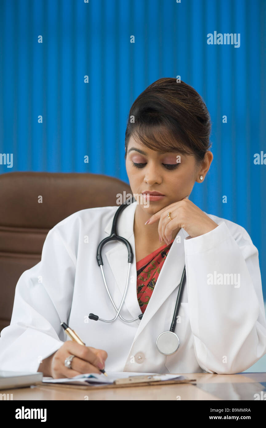 Female doctor writing on a sheet of paper Stock Photo - Alamy