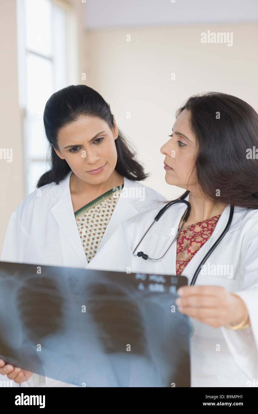 Female doctors examining an x-ray report Stock Photo