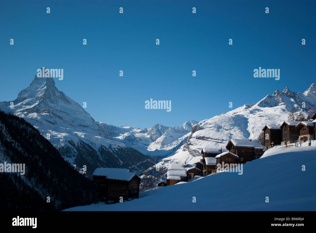 Snowed chalets backed by the Matterhorn in Zermatt The mountain is the most famous symbol of Switzerland. Stock Photo