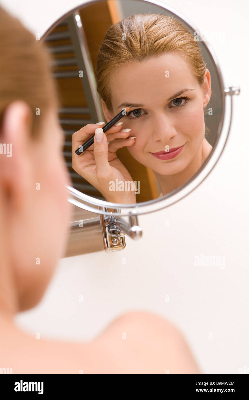 Young pretty woman doing makeup using eyebrow liner Stock Photo