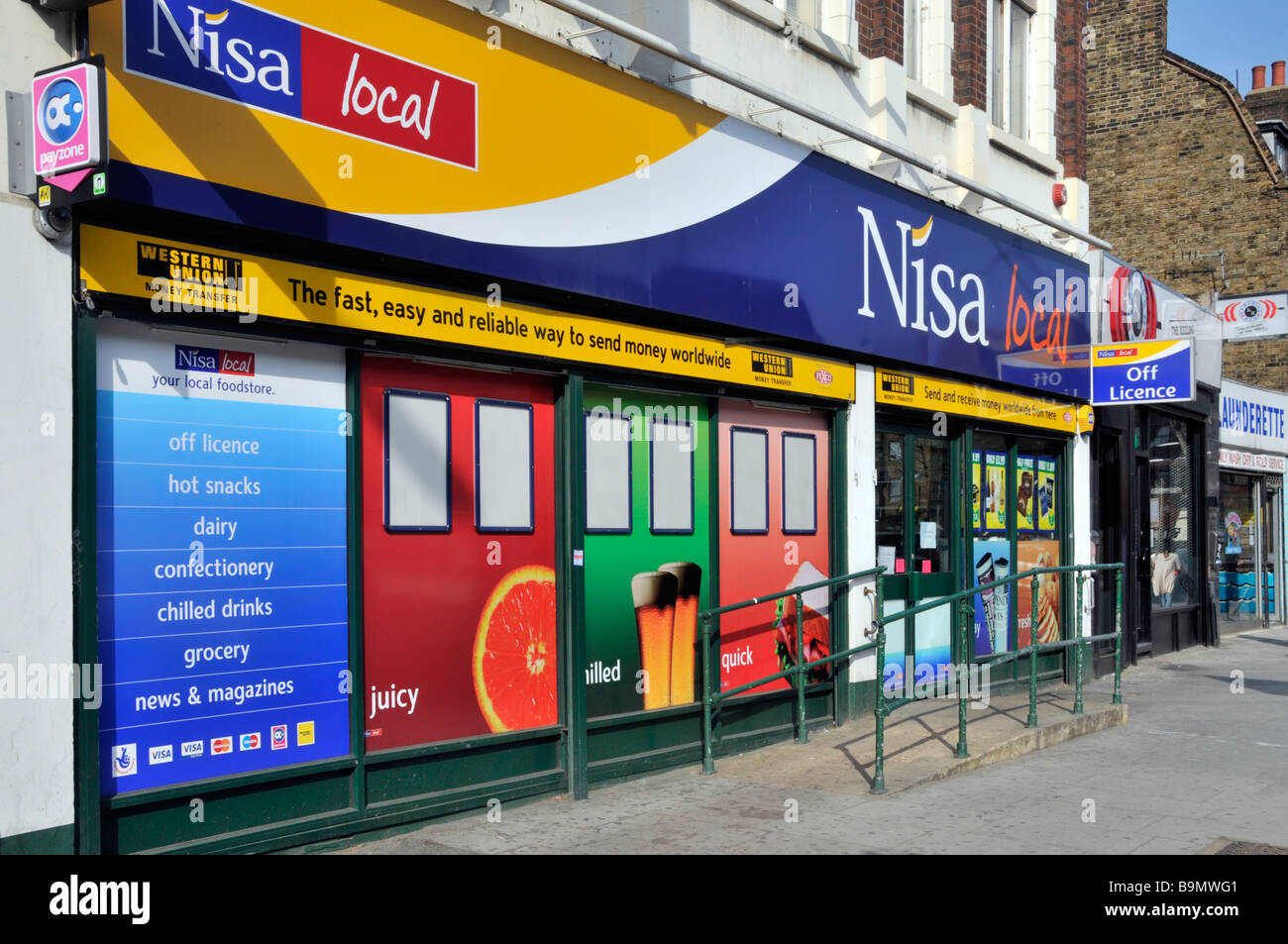 Shopper outside Nisa business & local convenience store shop front wheelchair access ramp Western Union signs at Bow in Tower Hamlets East London UK Stock Photo