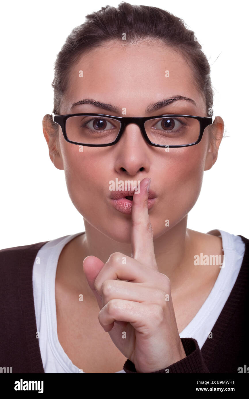 Attractive female with her finger to her mouth gesturing for quiet isolated on white background Stock Photo