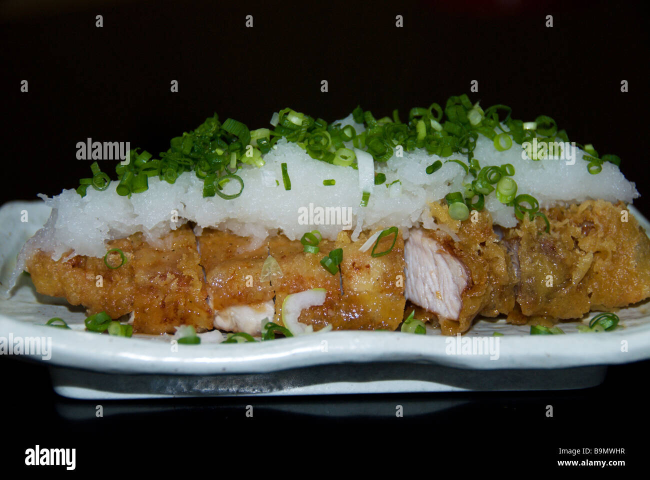 Deep fried pork topped with grated daikon radish and chopped onions - Japanese izakaya pub food Stock Photo