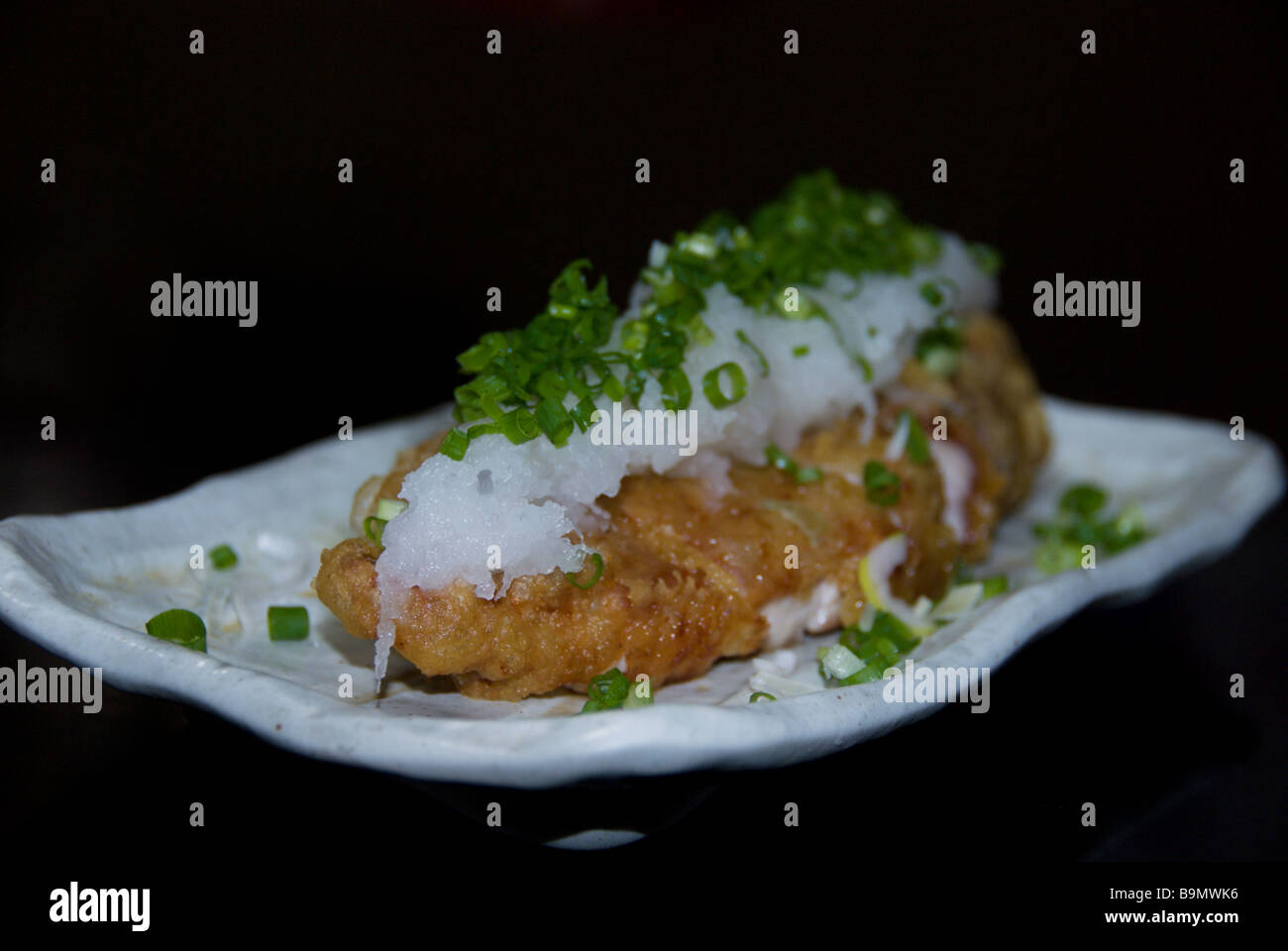 Deep fried pork topped with grated daikon at an Izakaya in Japan Stock Photo