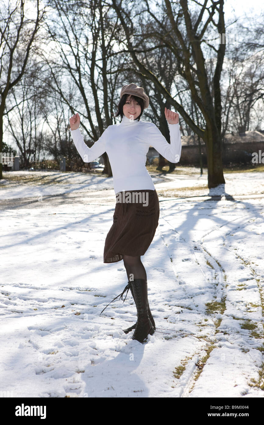 Frau geniesst den Schnee im Winter bei Sonne und modischer KLeidung Stock Photo