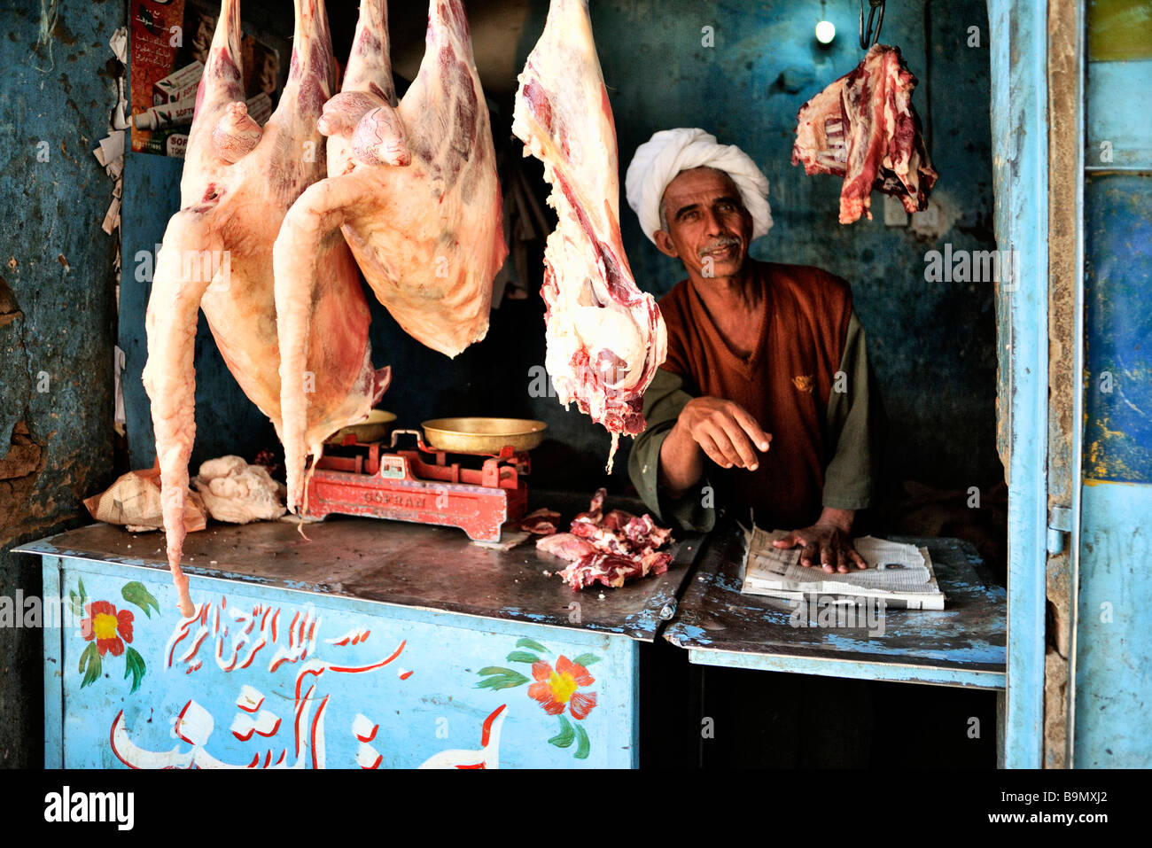 Butcher shop in town of Debba in northern Sudan, with man and sheep or goats hanging in front of shop Stock Photo