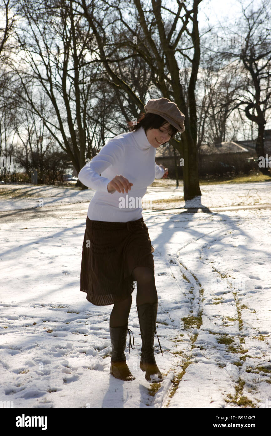 Frau geniesst den Schnee im Winter bei Sonne und modischer KLeidung Stock Photo