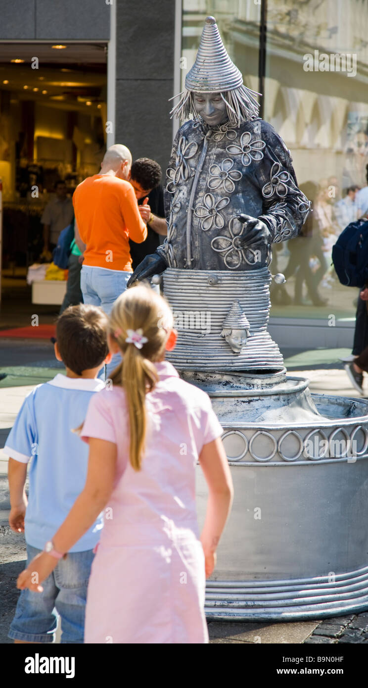 Street entertainer in silver costume with children Munich Germany Stock Photo