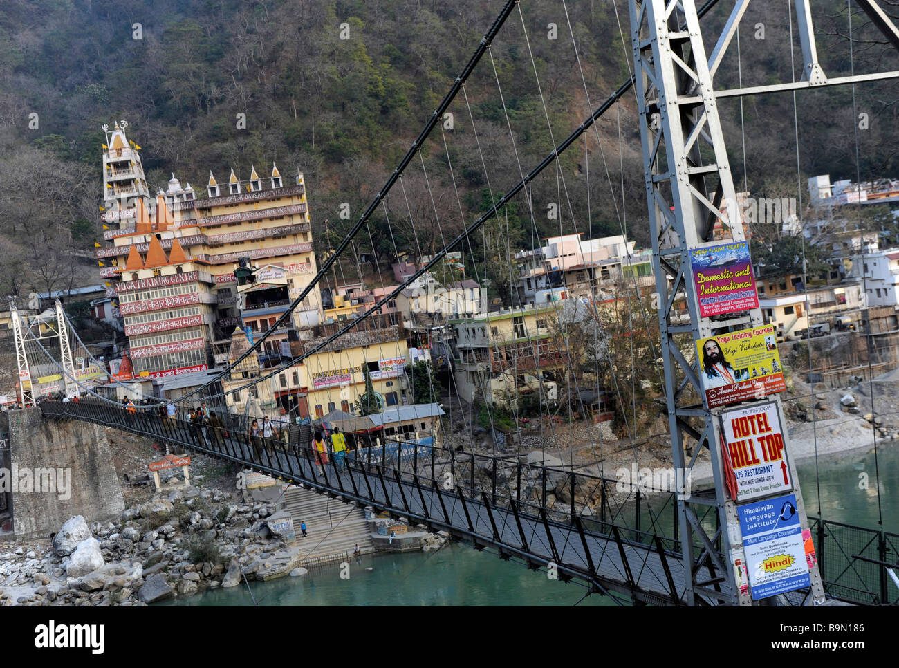 view of Lakshman Jhula hanging bridge Rishikesh with posters advertising yoga Rishikesh Stock Photo