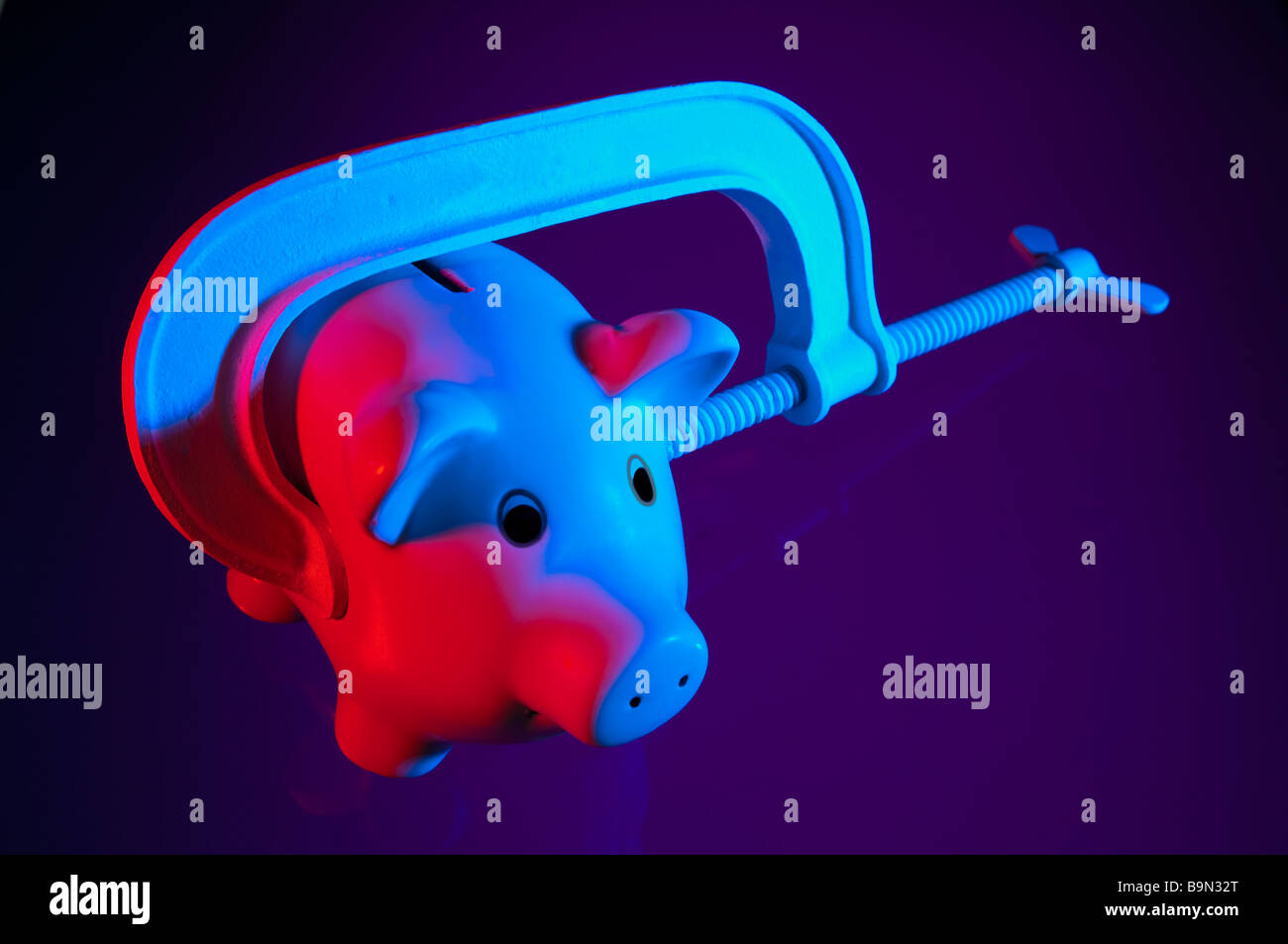 Credit squeeze concept - piggy bank in clamp. Stock Photo