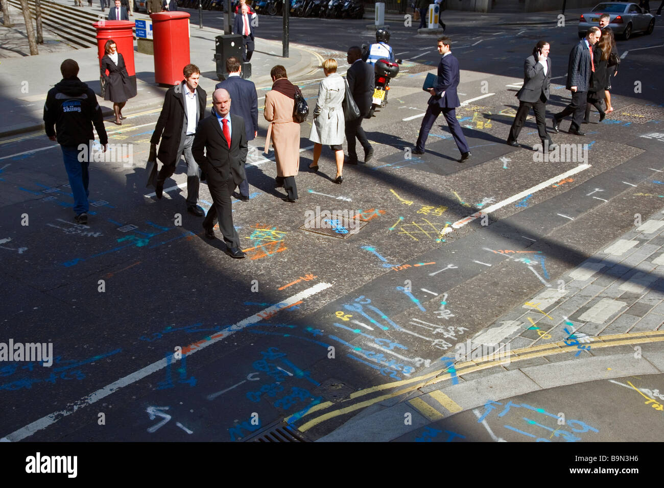 people crossing a street covered in markings in london Stock Photo Alamy