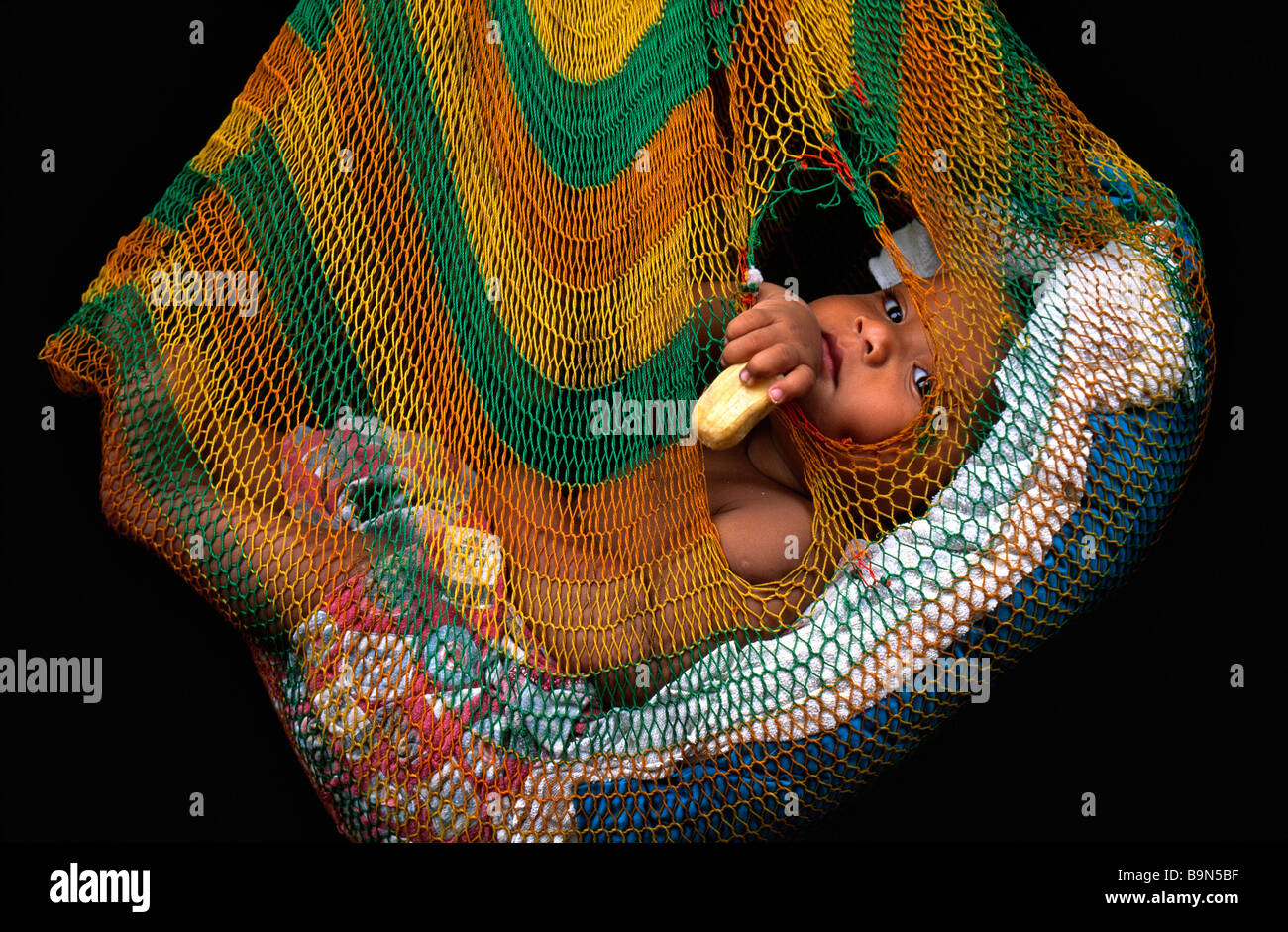 Papua New Guinea, Southern Highlands Province, Kode Dumbiali, Huli Tribe, young child in a bilum (a traditional woven bag used Stock Photo