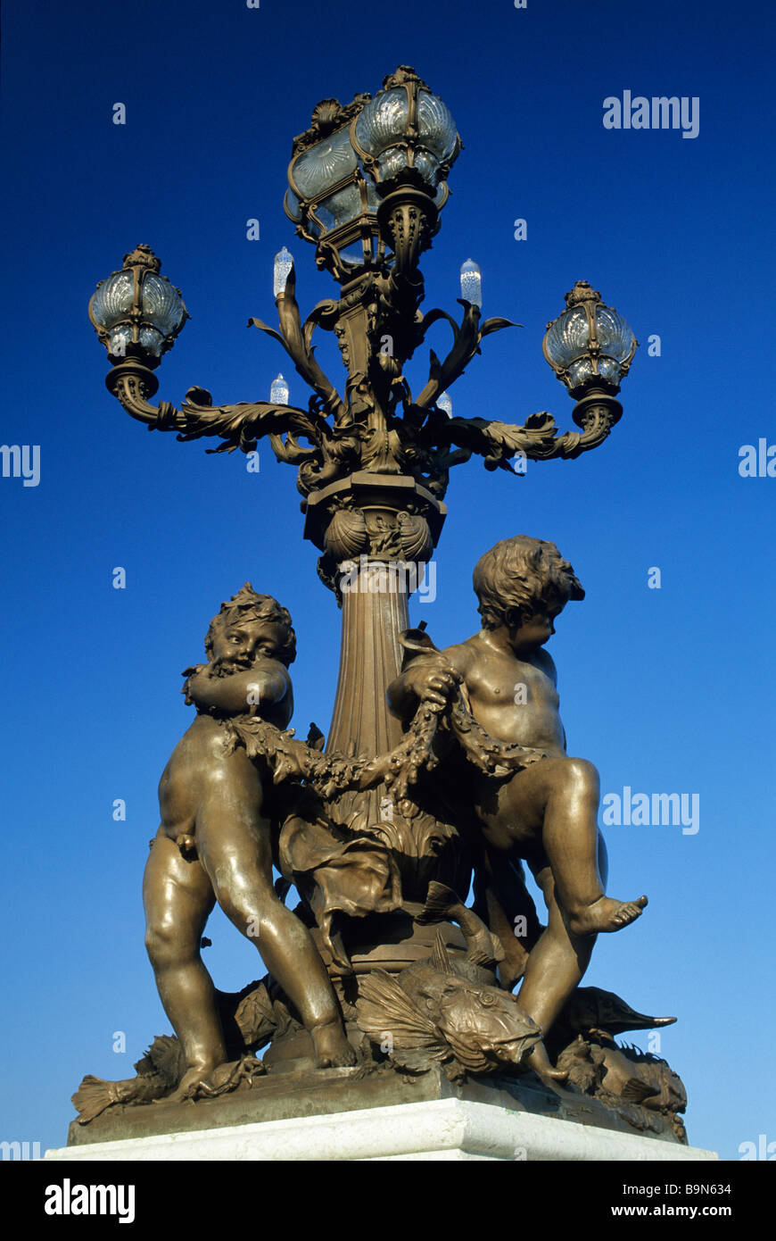 France, Paris, Pont Alexandre III, bronze lamppost, Ronde d'Amours (Loves Round) sculpture mounting the bridge balustrade Stock Photo