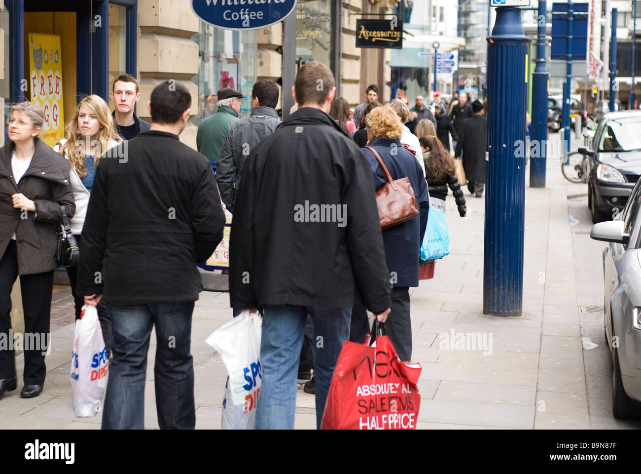 People walking on sidewalk in Manchester city centre UK Stock Photo